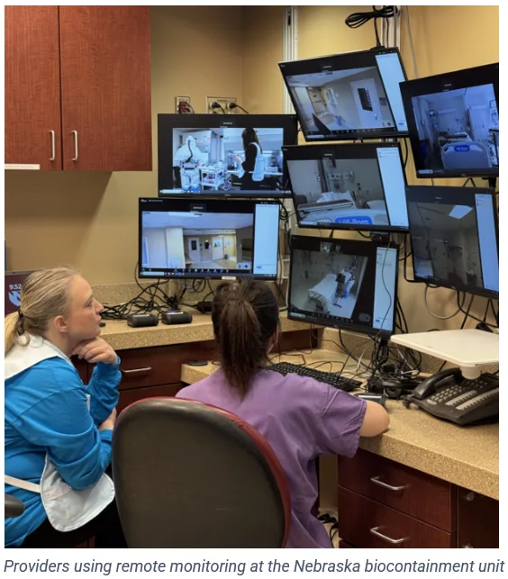 A photo of providers at Nebraska Medicine's quarantine unit looking at computer screens showing live video footage of patient rooms.