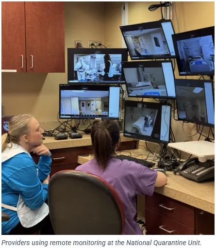 A photo of providers at Nebraska Medicine's quarantine unit looking at computer screens showing live video footage of patient rooms.