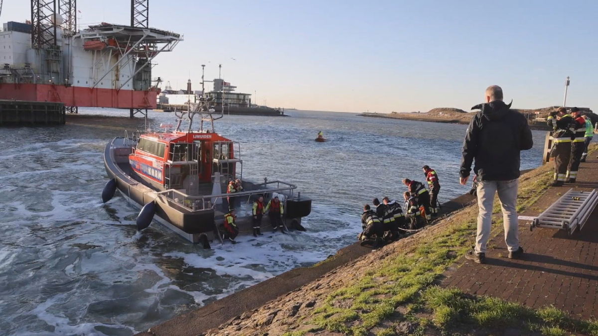 Brandweerboot en hulpdiensten bij een te water geraakte auto in IJmuiden - Beeld: HFV