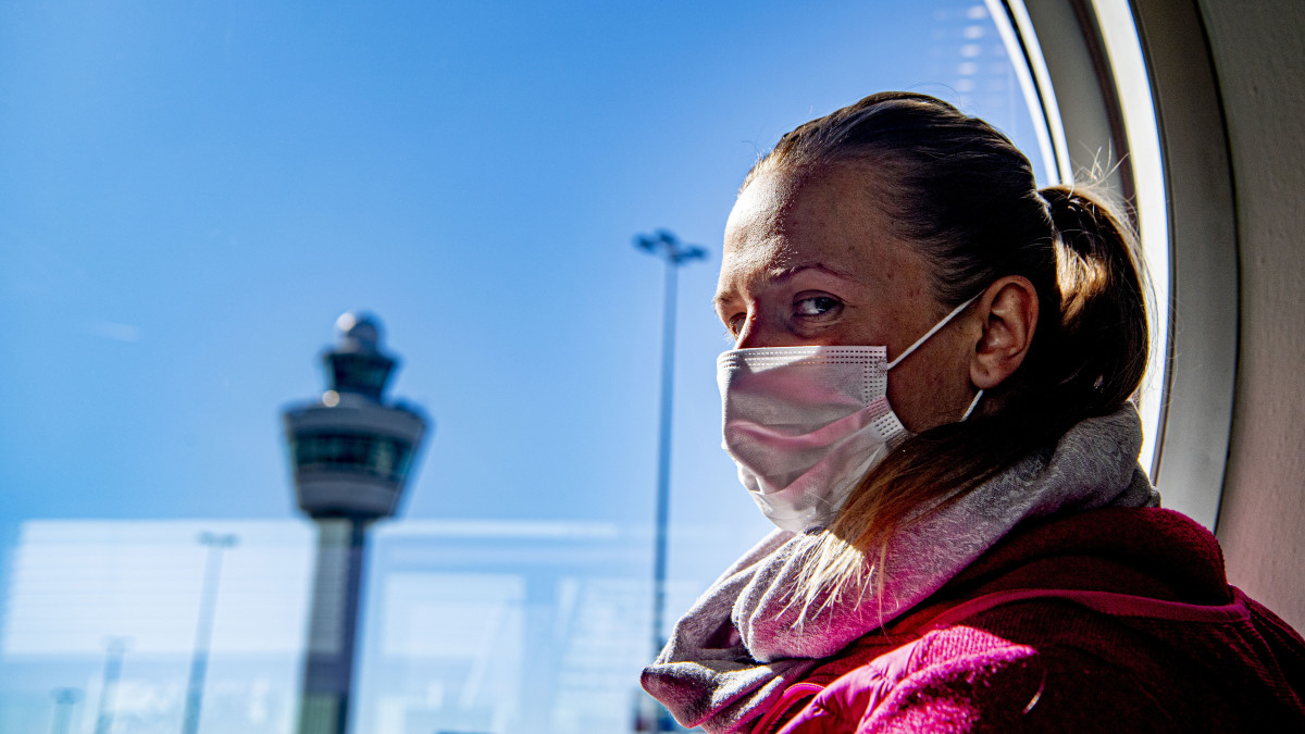Vrouw draagt een mondkapje op Schiphol (ANP)