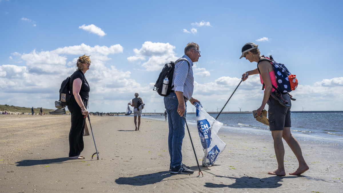 Vrijwilligers maken het strand schoon met tangen - Bron: Paula Romein I Stichting De Noordzee