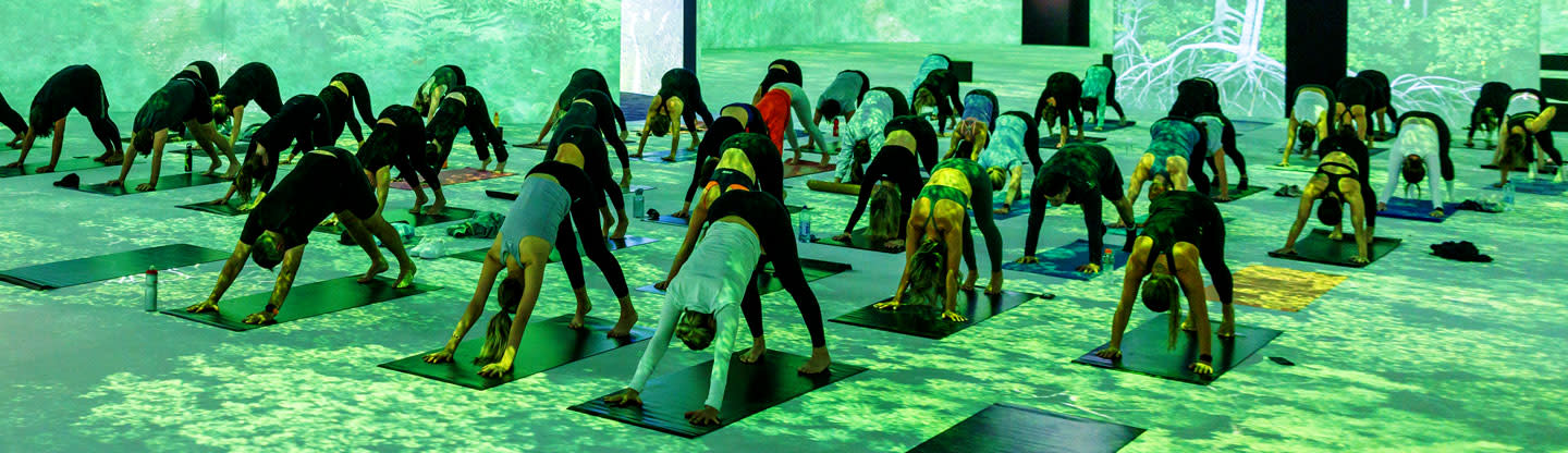 Group of people on yoga mats doing a yoga pose position in THE LUME Melbourne. 