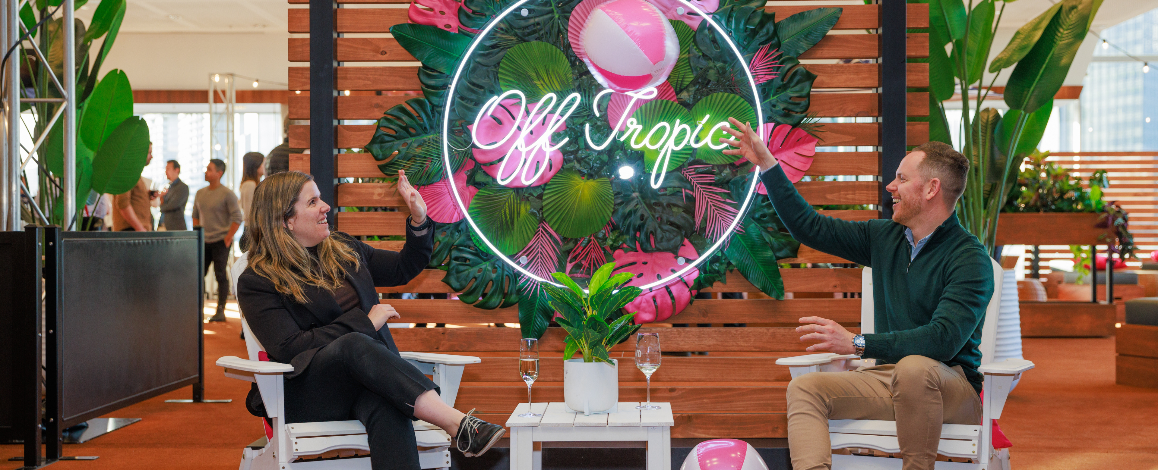 Front entrance to Off tropic space, With signage and two people sitting enjoying their wine on white chairs.  