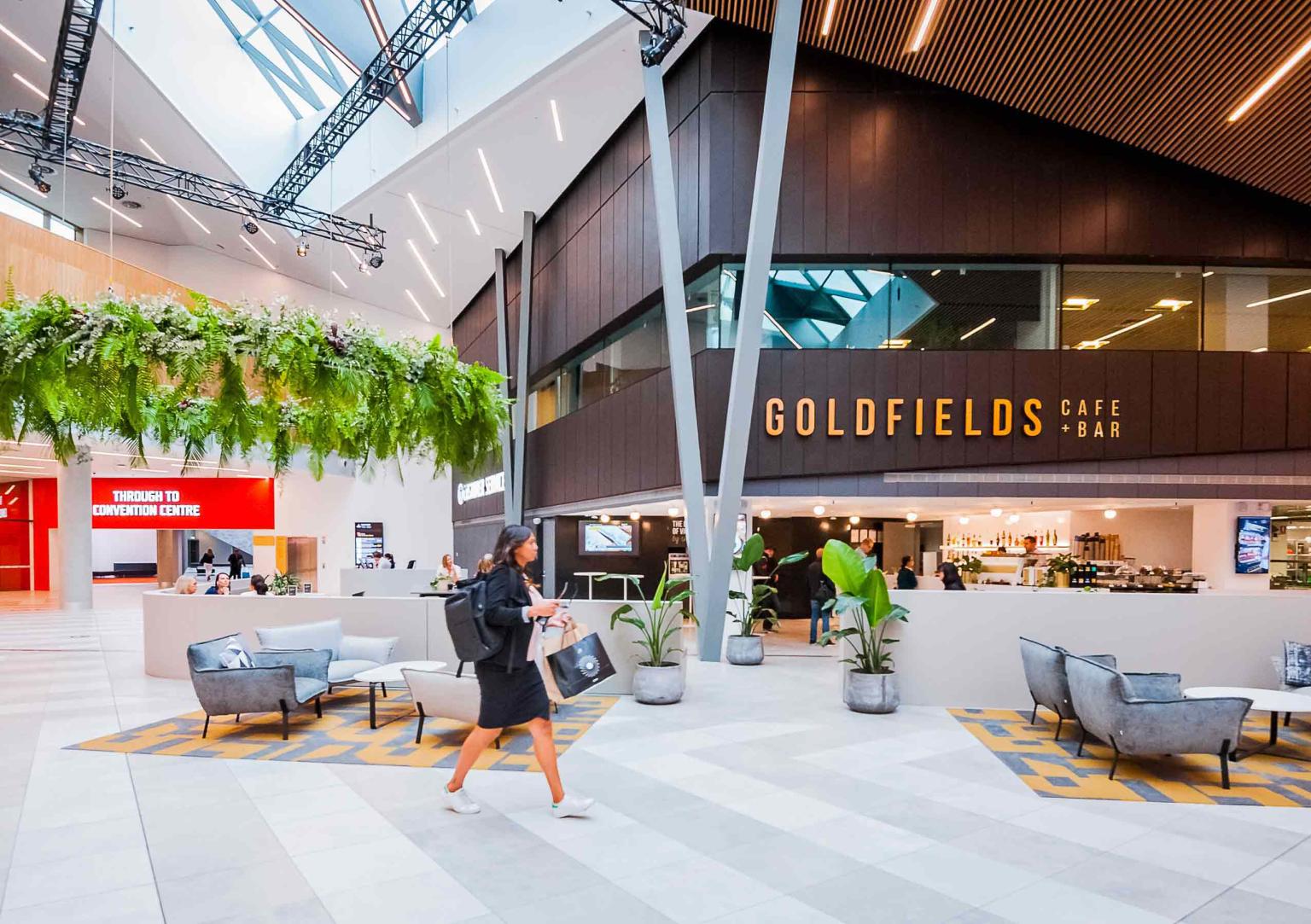 One woman walks through the walkway in front of Goldfields Café in the Melbourne Exhibition building foyer. 