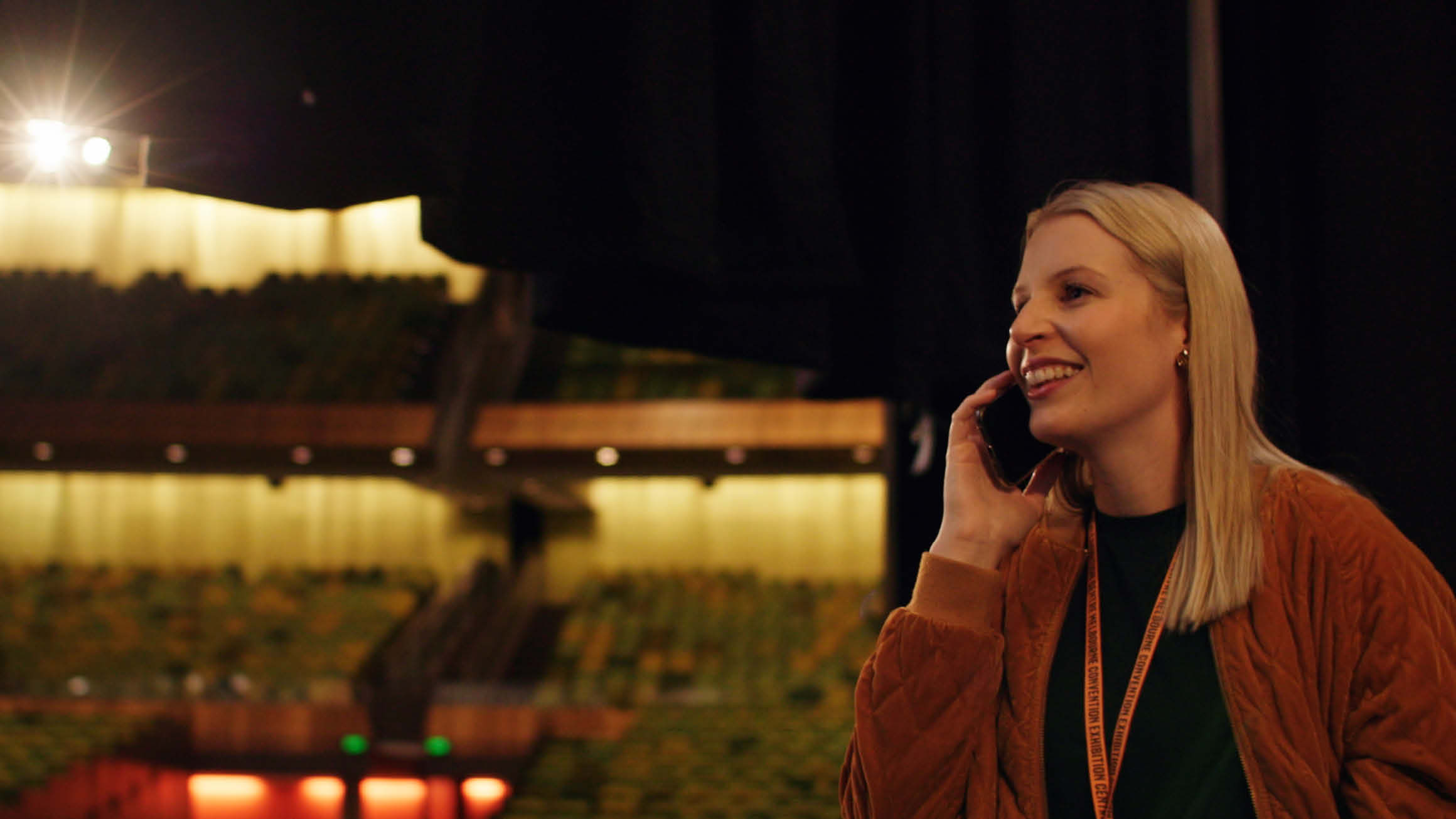 Anthea Fahey inside the Plenary at MCEC (Melbourne Convention and Exhibition Centre), speaking on the phone.