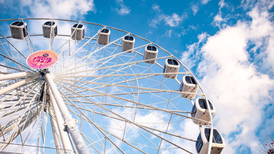 Close up of a ferris wheel against the bright blue sky. 