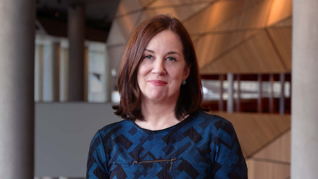 Image of Natalie O'Brien AM, Chief Executive of Melbourne Convention and Exhibition Centre, smiling at the camera while standing in the centre's atrium.