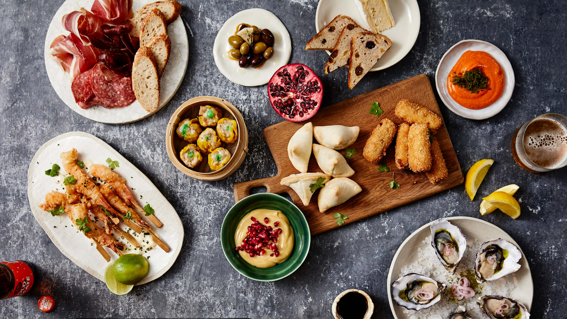 Bird's eye view of a table filled with savory food, including various nibbles and dips.