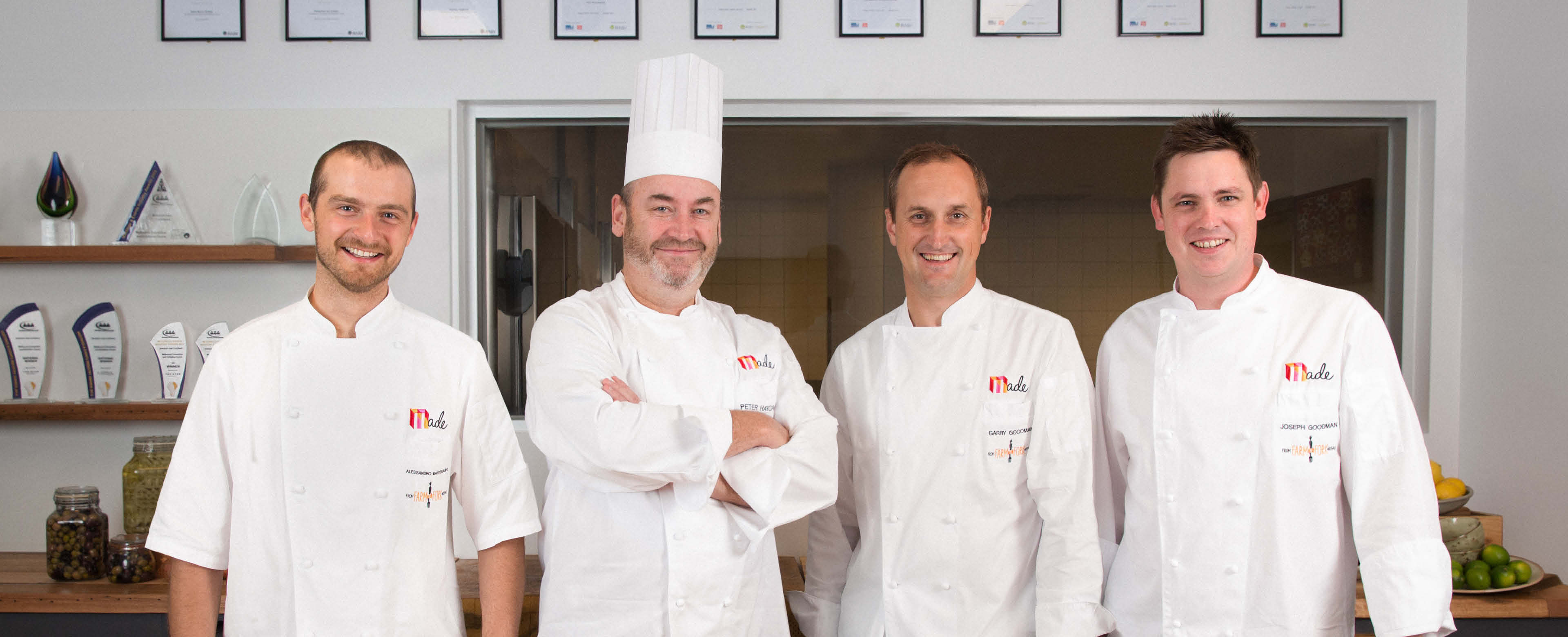 Four chefs standing in a row, dressed in MCEC (Melbourne Convention and Exhibition Centre) chef uniforms.