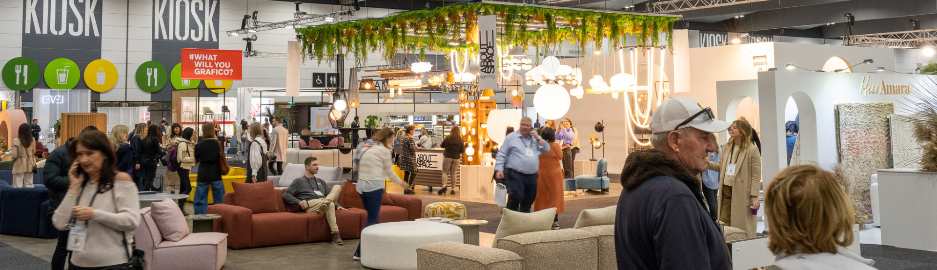 Crowd of people walking through and around a furniture display. 