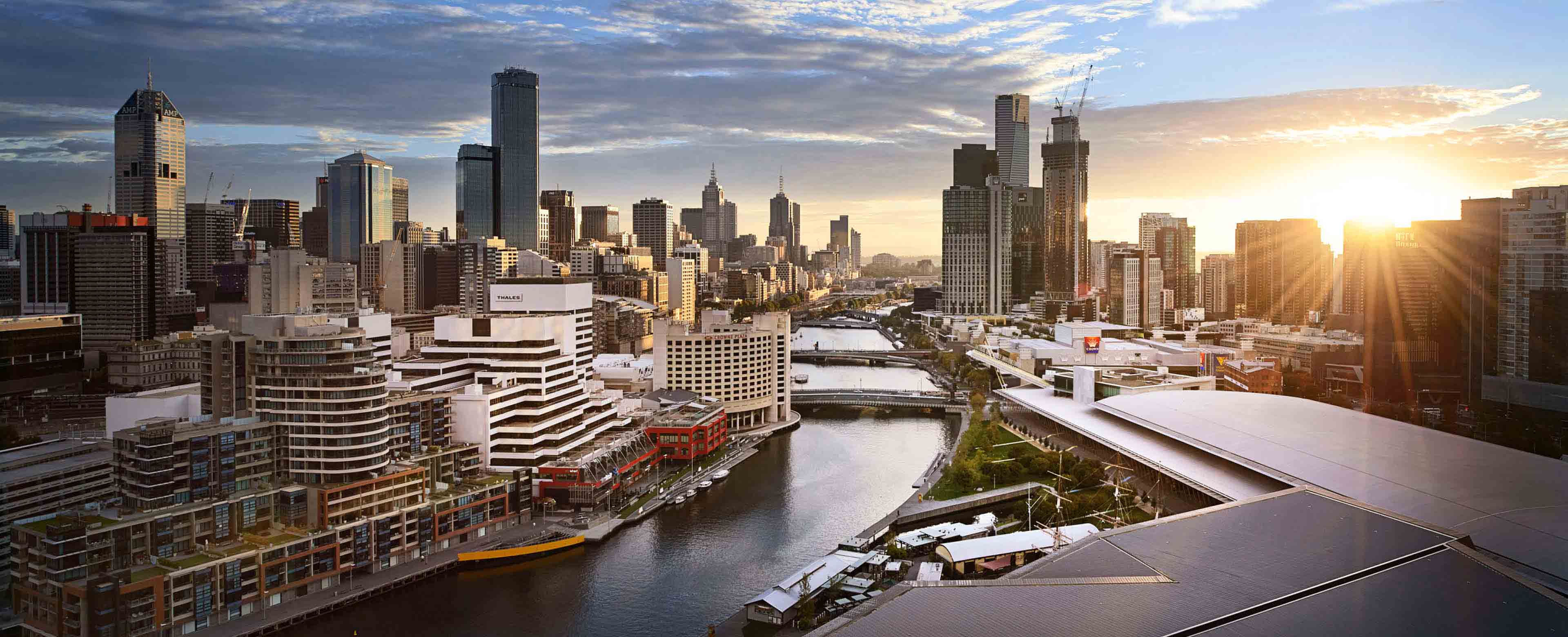 This image shows a bird's-eye view of the Yarra/Birrarung River and the buildings that surround it in Melbourne, Australia, including the Melbourne Convention and Exhibition Centre.