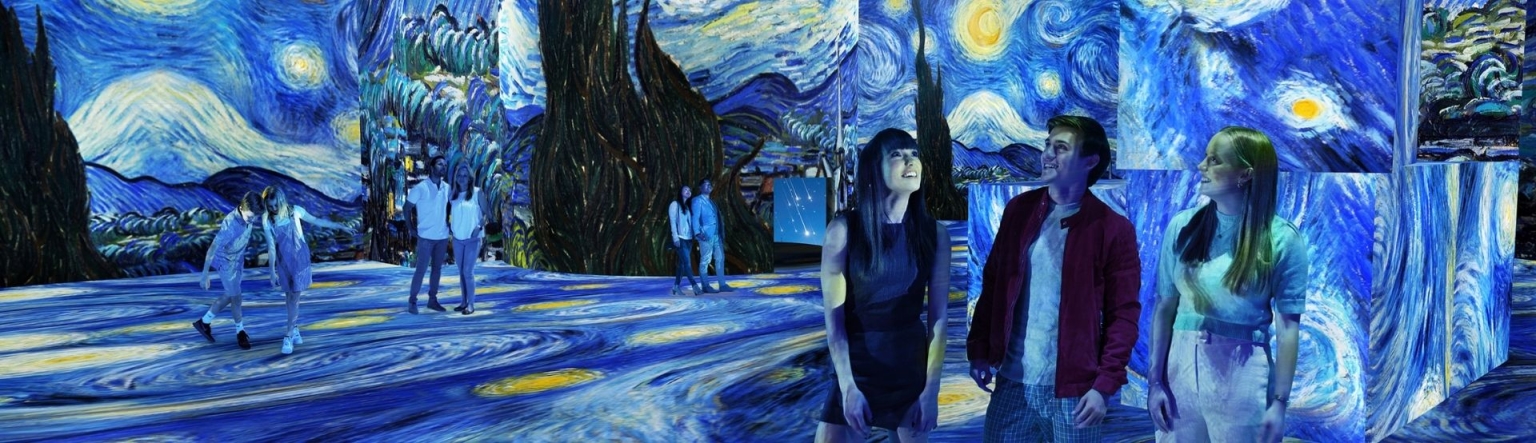 People scattered through THE LUME Melbourne which displays Vincent Van Gogh's starry night artwork. 