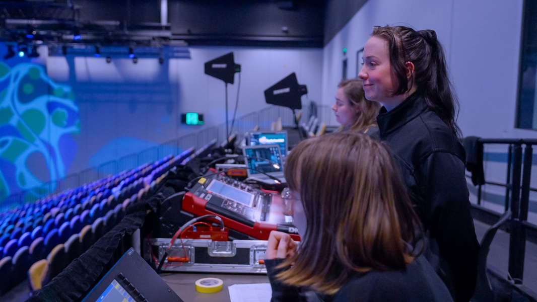 Group of woman working on a technology desk for a stage show. 