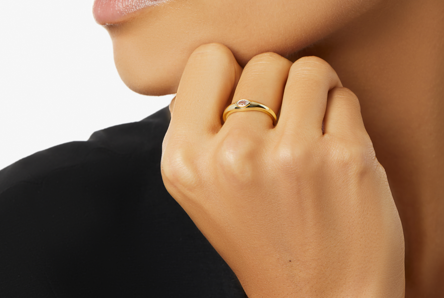 woman wearing a gold solitaire ring with gemstones