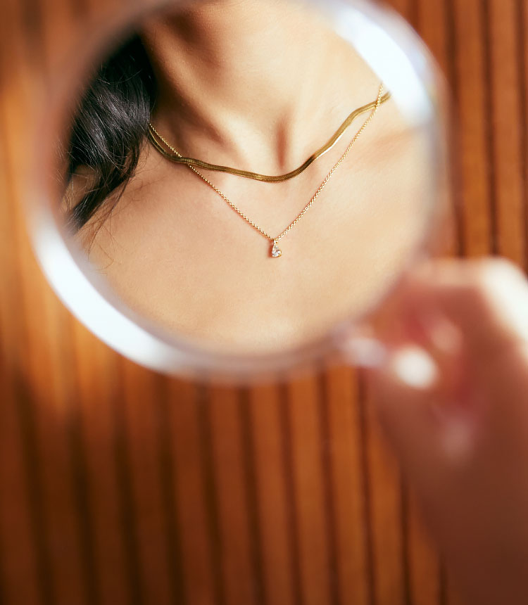 layered diamond necklace in a mirror