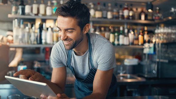 man at bar counter on tablet