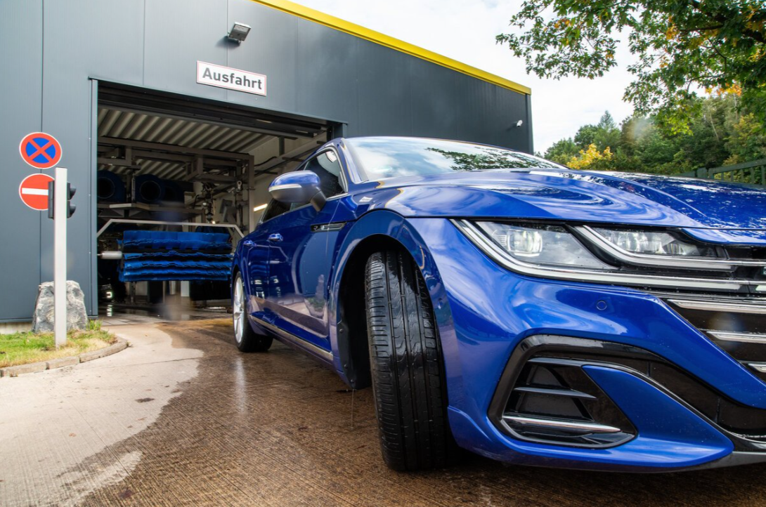 Blaues Auto fährt aus der Waschstraße