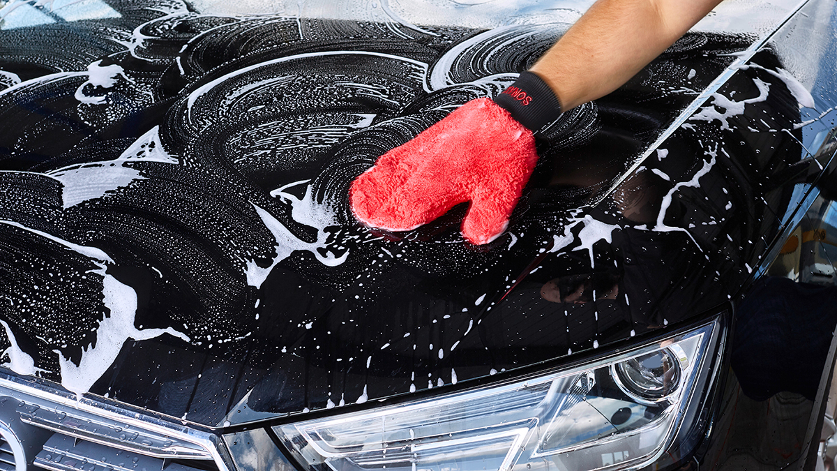 Auto wird mit Microfaser Waschhandschuh gewaschen.