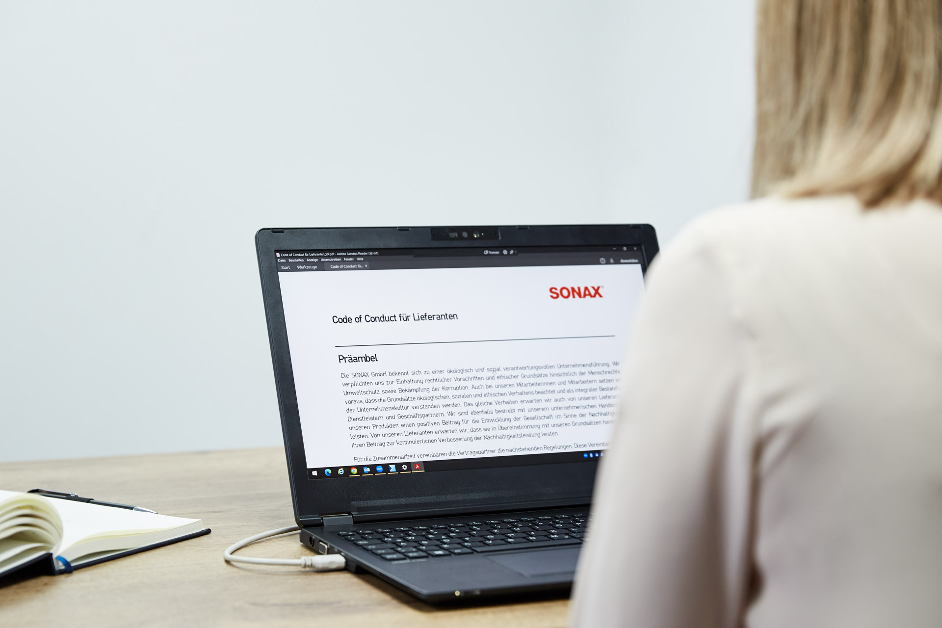 Document "Code of conduct for suppliers" by SONAX is open on a laptop. 