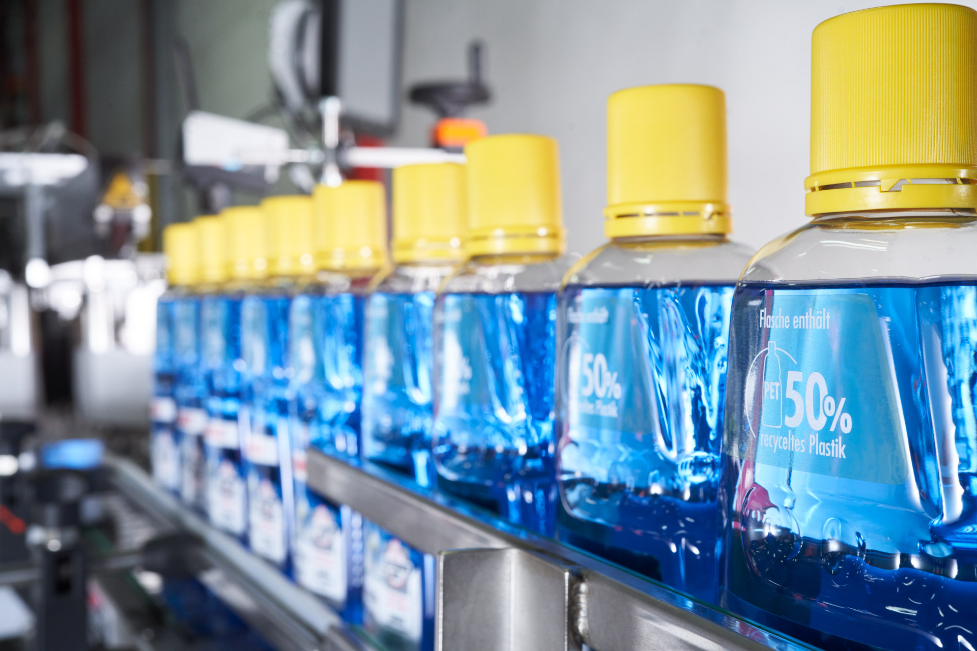 Los envases fabricados con un 50% de plástico reciclado se llenan en la producción.