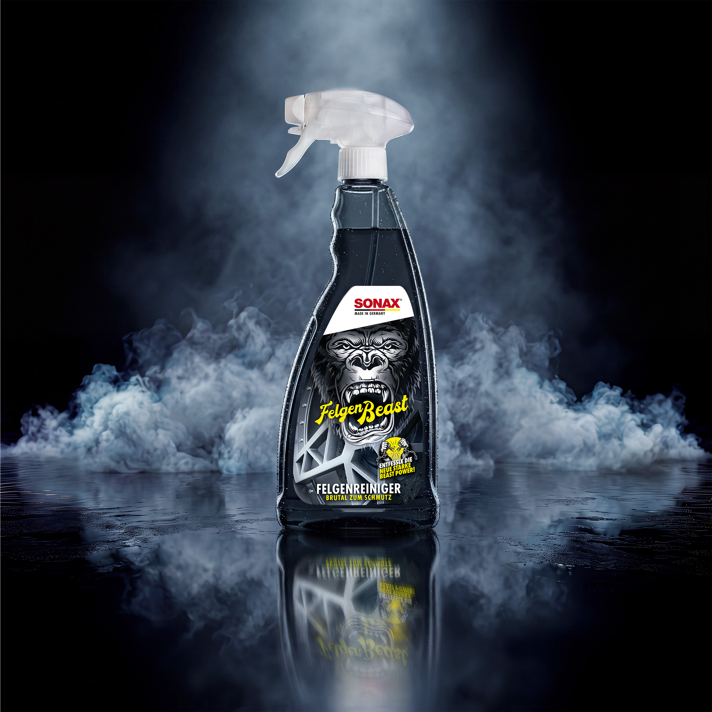 SONAX Felgenreiniger FelgenBeast in transparenter Sprühflasche vor dunklem, rauchigem Hintergrund.