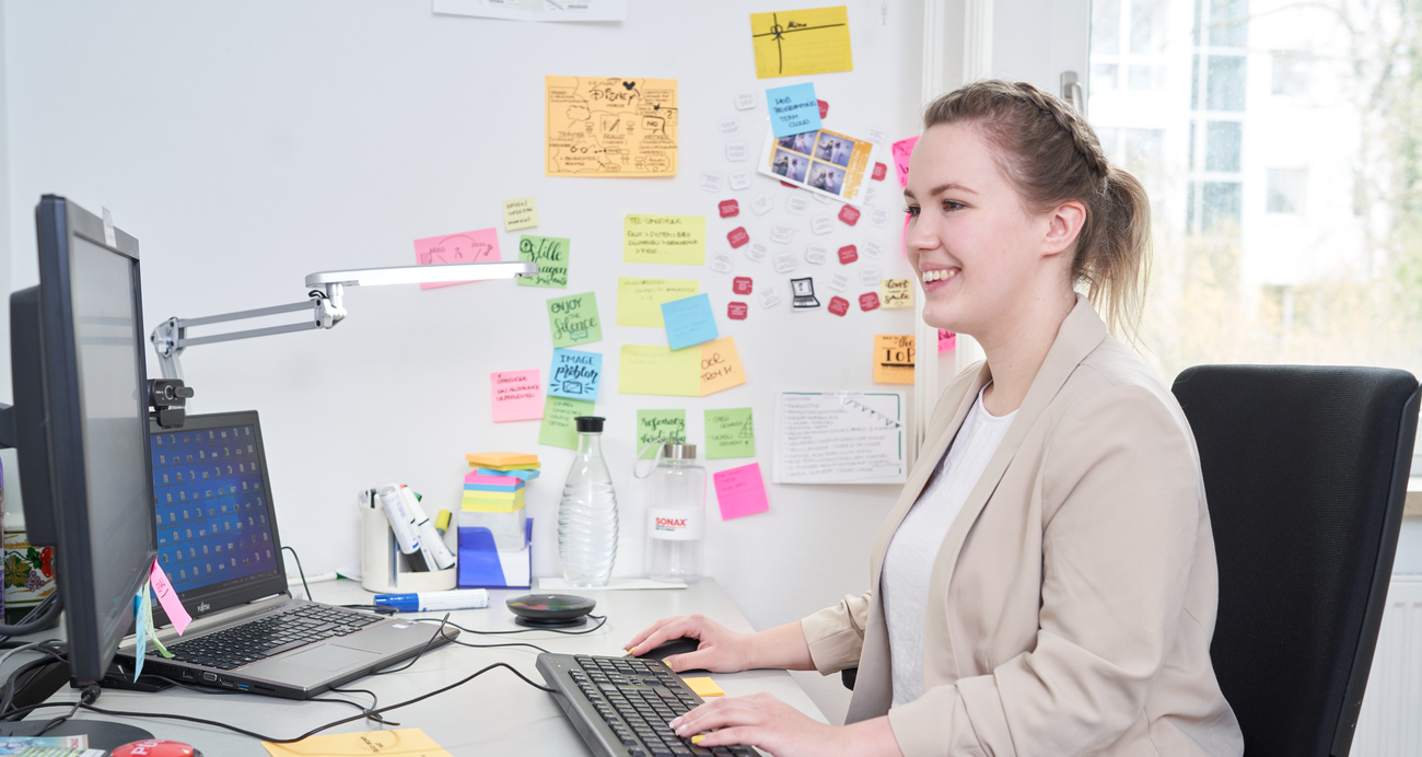 Mediengestalterin für Beratung und Planung arbeitet am Schreibtisch.