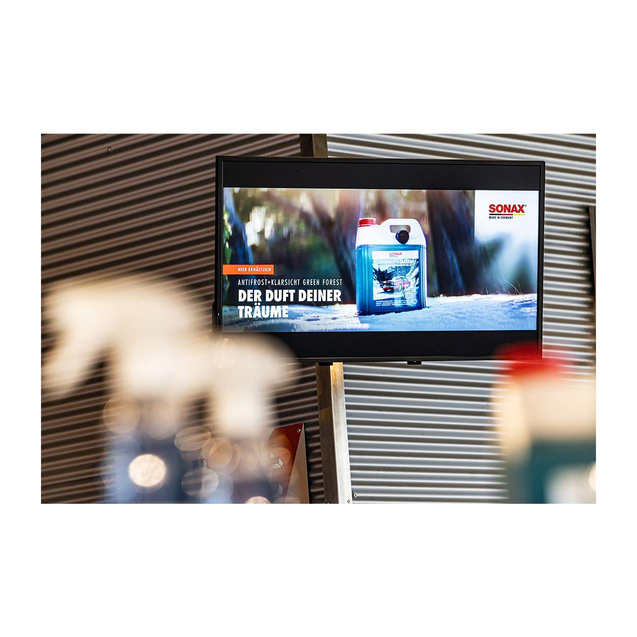 Werbedisplay und Plakate für SONAX Autopflegeprodukte mit Green Forest Motiv