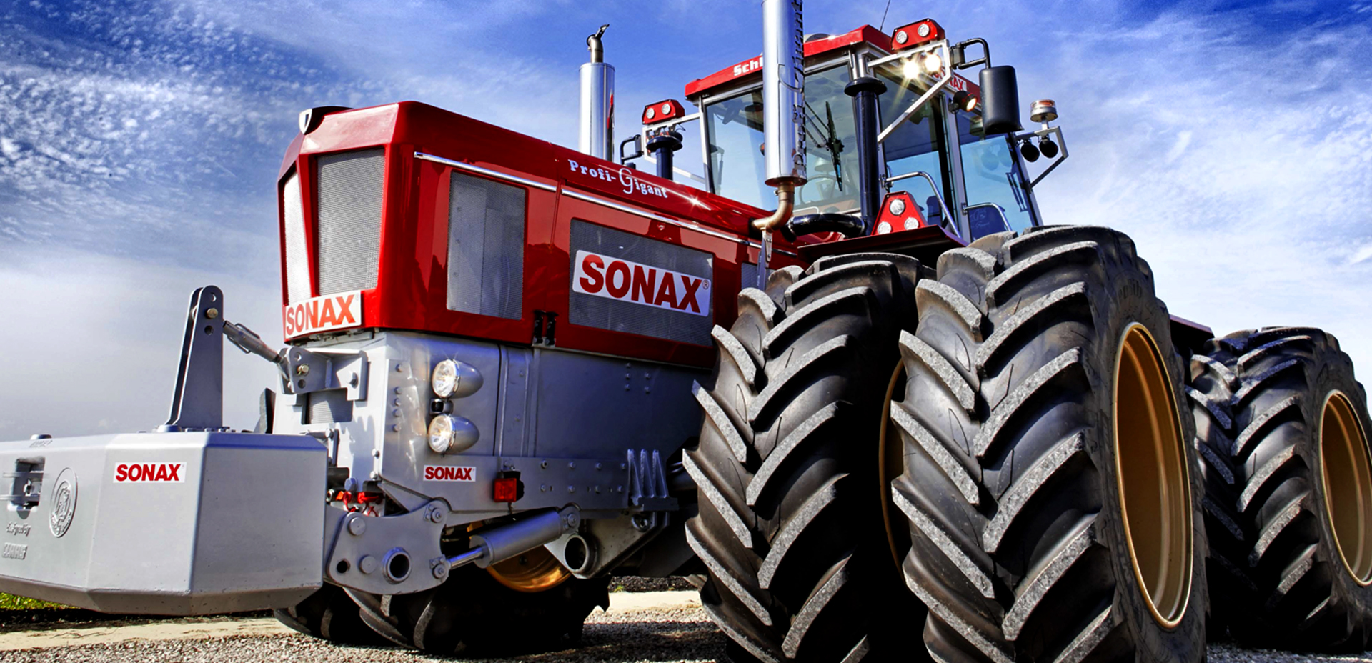 Ein glänzender roter Traktor mit SONAX-Aufklebern.