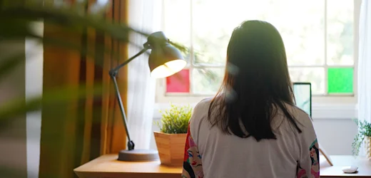 female with long dark hair studying online accounting and bookkeeping course on laptop from home