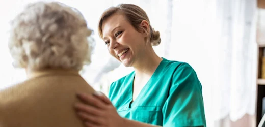 Senior care worker taking care of an elderly with a smile on her face