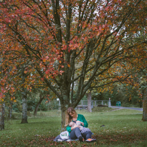 Mother breastfeeding under a tree