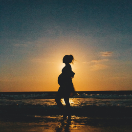 pregnant woman on the beach during sunset