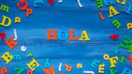 Hola spelled in colorful letters on blue background