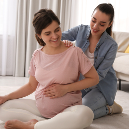 Doula massaging pregnant woman