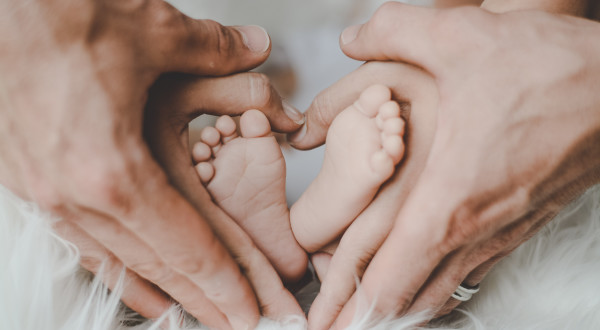 New baby feet in parents' hands