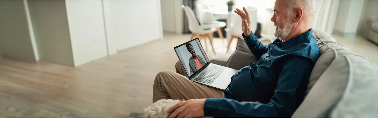 man using a computer to have a video call with a person 