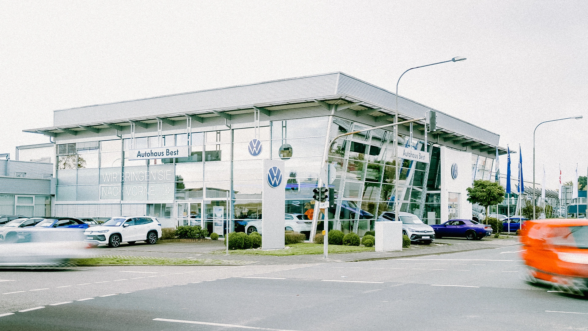 Eine Aufnahme des Volkswagen Autohauses in Mühlheim am Main, dass die Gebäude und Volkswagen Fahrzeuge vor dem Gebäude, sowie Parkplätze zeigt.