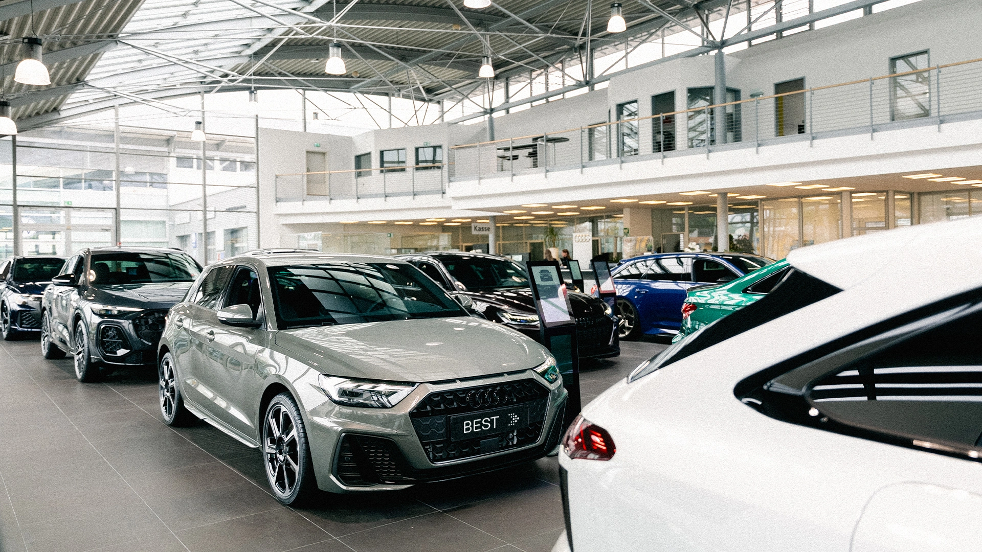 Best Header Eine Innenaufnahme des Audi Autohauses in Mühlheim am Main, die den Showroom und einige Audi Modelle zeigt.