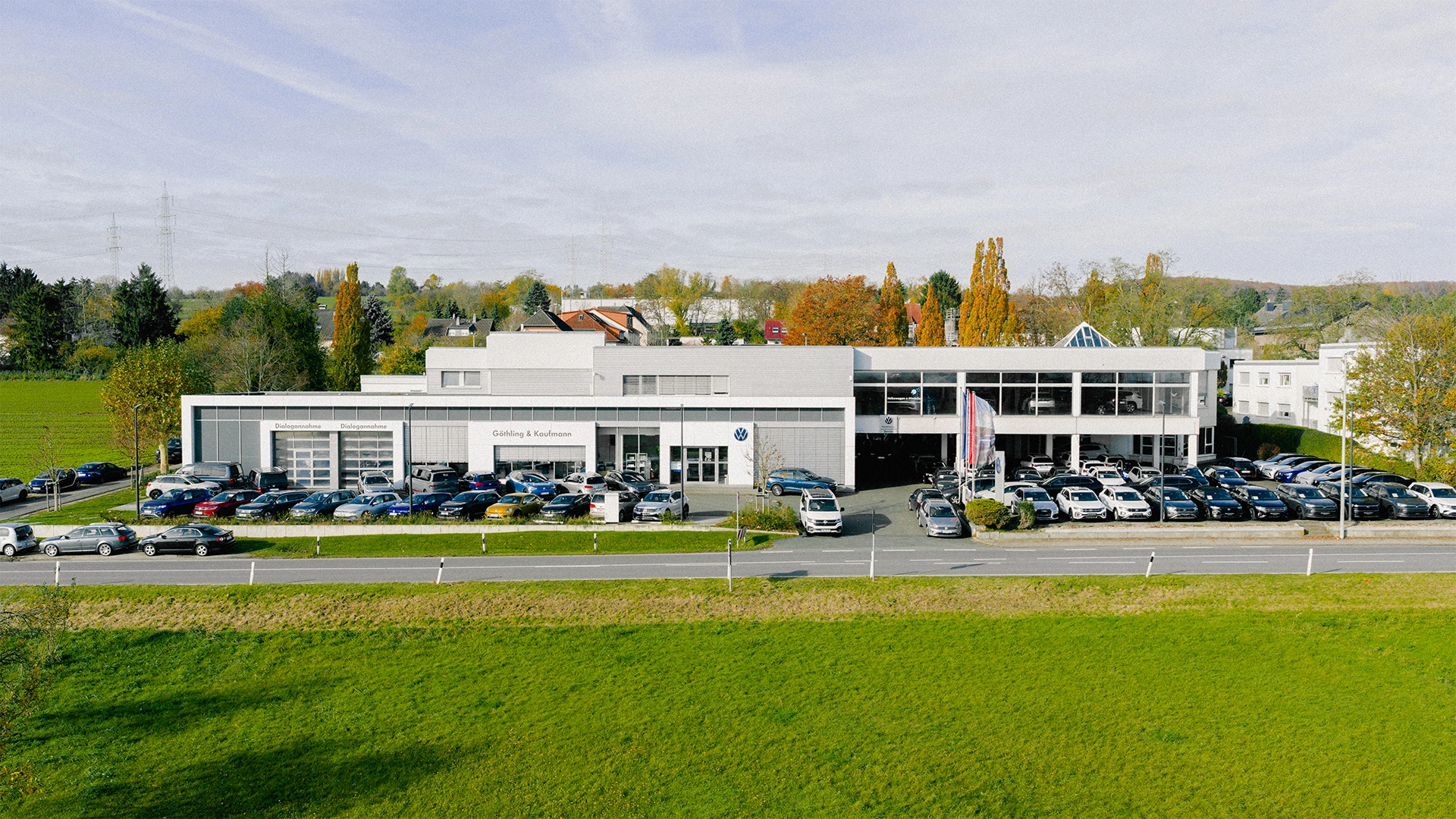 Eine Aufnahme des Volkswagen Autohauses in Hofheim am Taunus, dass die Gebäude und Volkswagen Fahrzeuge vor dem Gebäude, sowie die Einfahrt und die Rheingaustraße zeigt.