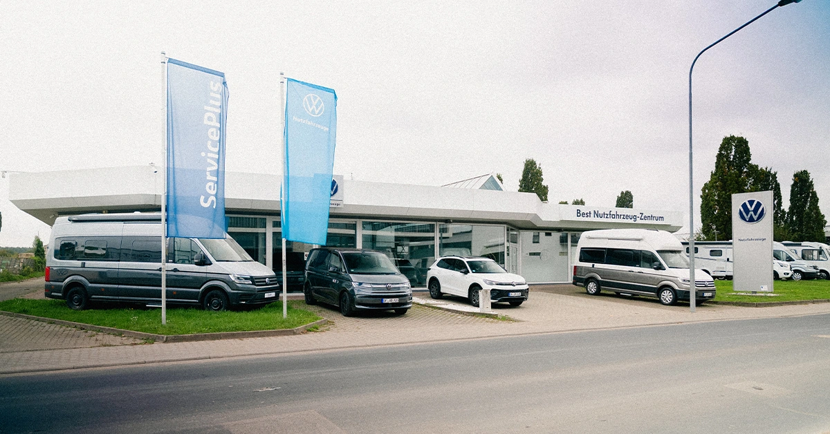 Eine Aufnahme des Volkswagen Nutzfahrzeuge Autohauses in Mühlheim am Main, die das Gebäude und Volkswagen Nutzfahrzeuge vor dem Gebäude zeigt.