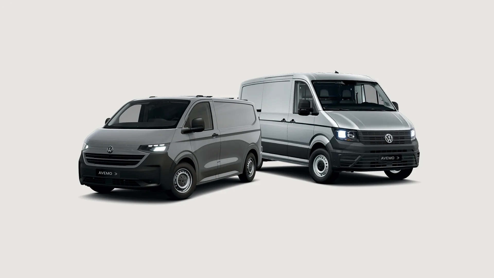 26-003 Nutzfahrzeuge Jahresstart Kampagne | Headerbild Zwei silberne Volkswagen Transporter stehen schräg versetzt auf einem neutralen, hellen Hintergrund. Beide Fahrzeuge tragen das AVEMO-Kennzeichen und präsentieren ein modernes, funktionales Design für den gewerblichen Einsatz.