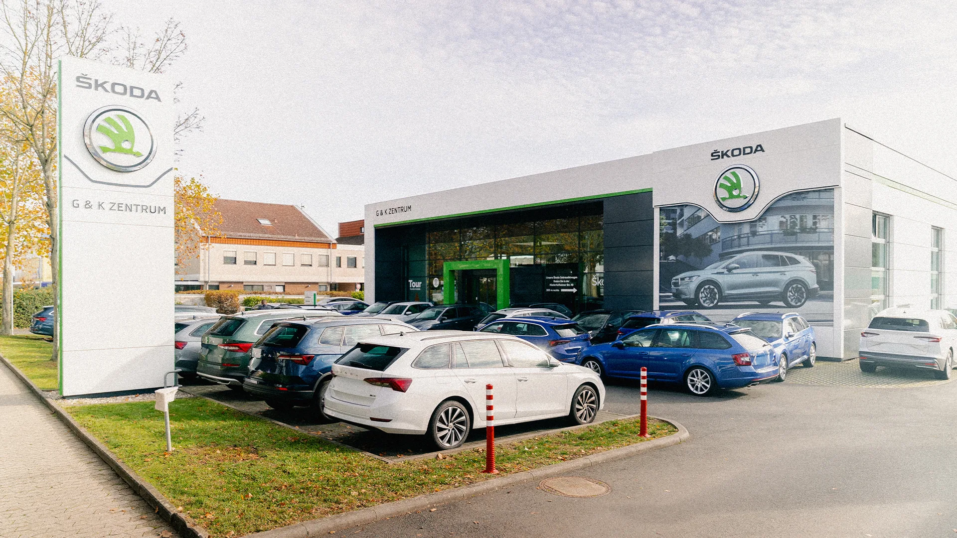 Eine Aufnahme des Škoda Autohauses in Hofheim am Taunus, dass die Gebäude und Škoda Fahrzeuge vor dem Gebäude, sowie Parkplätze zeigt.
