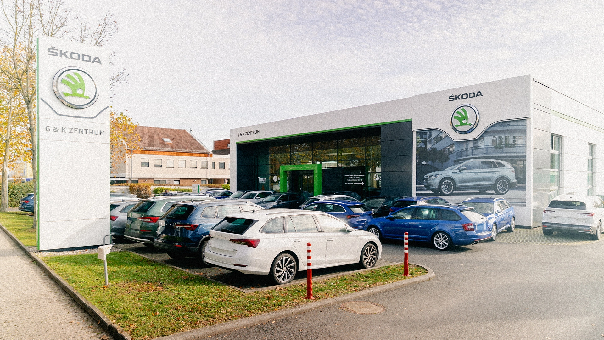 Škoda Hofheim am Taunus Header Eine Aufnahme des Škoda Autohauses in Hofheim am Taunus, dass die Gebäude und Škoda Fahrzeuge vor dem Gebäude, sowie Parkplätze zeigt.