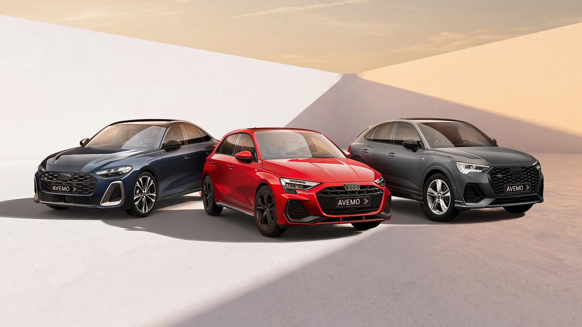 26-023 website Drei Audi-Fahrzeuge – eine blaue Limousine, ein roter Kompaktwagen und ein grauer SUV – stehen nebeneinander in einem hellen Studio vor einem minimalistischen, weiß-beigen Hintergrund mit warmem Lichteinfall. Alle Modelle tragen ein AVEMO-Kennzeichen.