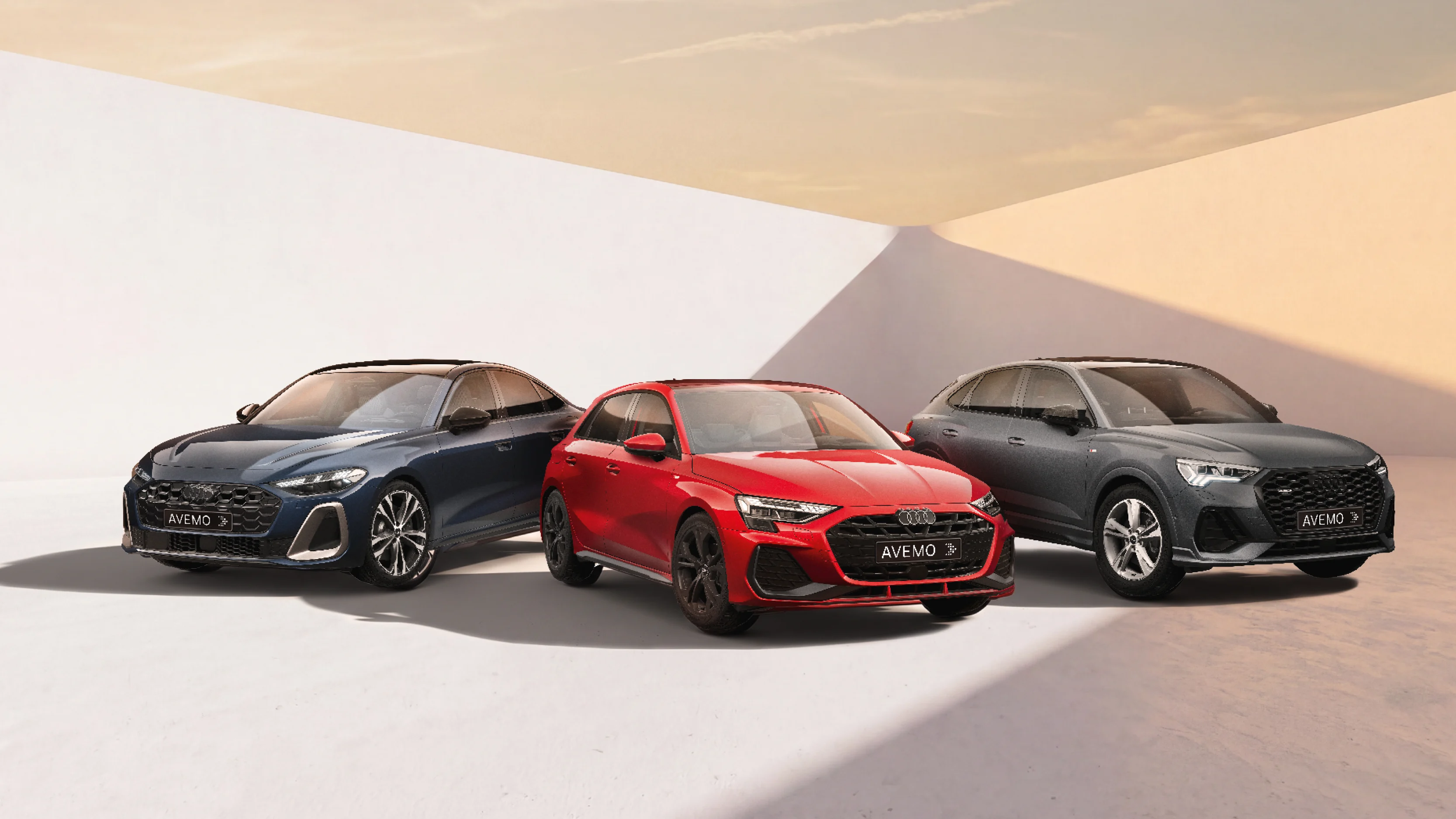 Drei Audi-Fahrzeuge – eine blaue Limousine, ein roter Kompaktwagen und ein grauer SUV – stehen nebeneinander in einem hellen Studio vor einem minimalistischen, weiß-beigen Hintergrund mit warmem Lichteinfall. Alle Modelle tragen ein AVEMO-Kennzeichen.