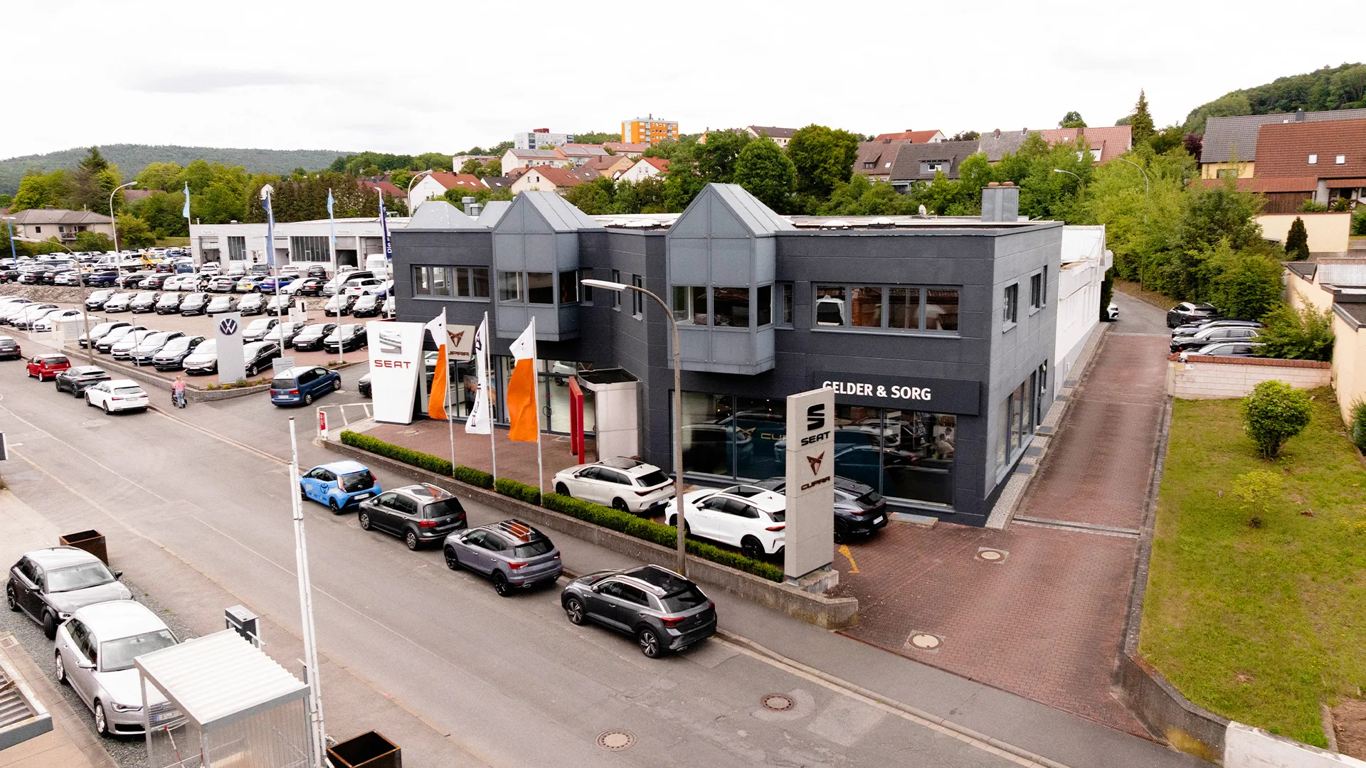 Eine Aufnahme des SEAT & CUPRA Autohauses in Lichtenfels, die das Gebäude sowie die Fahrzeuge vor dem Autohaus zeigt.