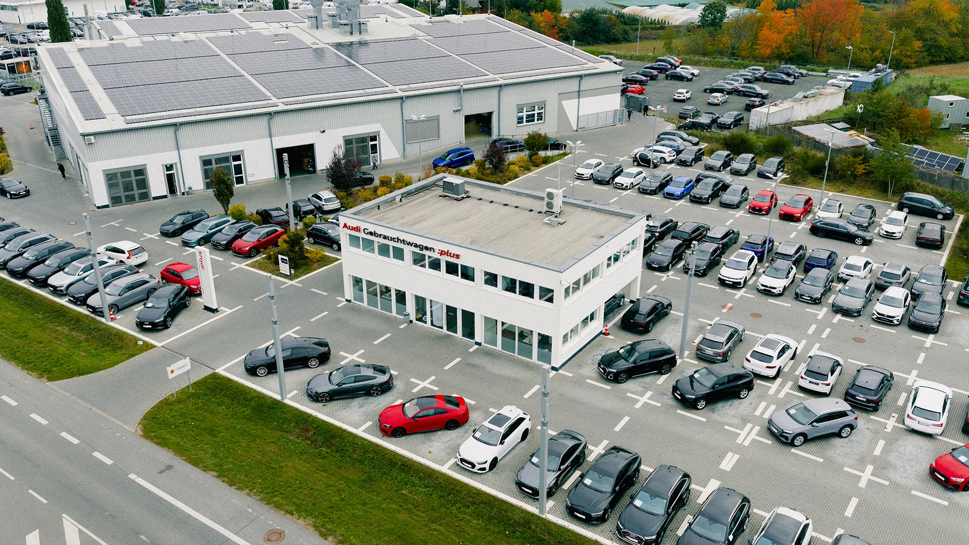 Audi Gebrauchtwagen Mühlheim am Main Header Eine Aufnahme des Audi Gebrauchtwagen Gebäudes in Mühlheim am Main, dass die Gebäude und Audi Fahrzeuge vor dem Gebäude, sowie die Einfahrt zeigt.