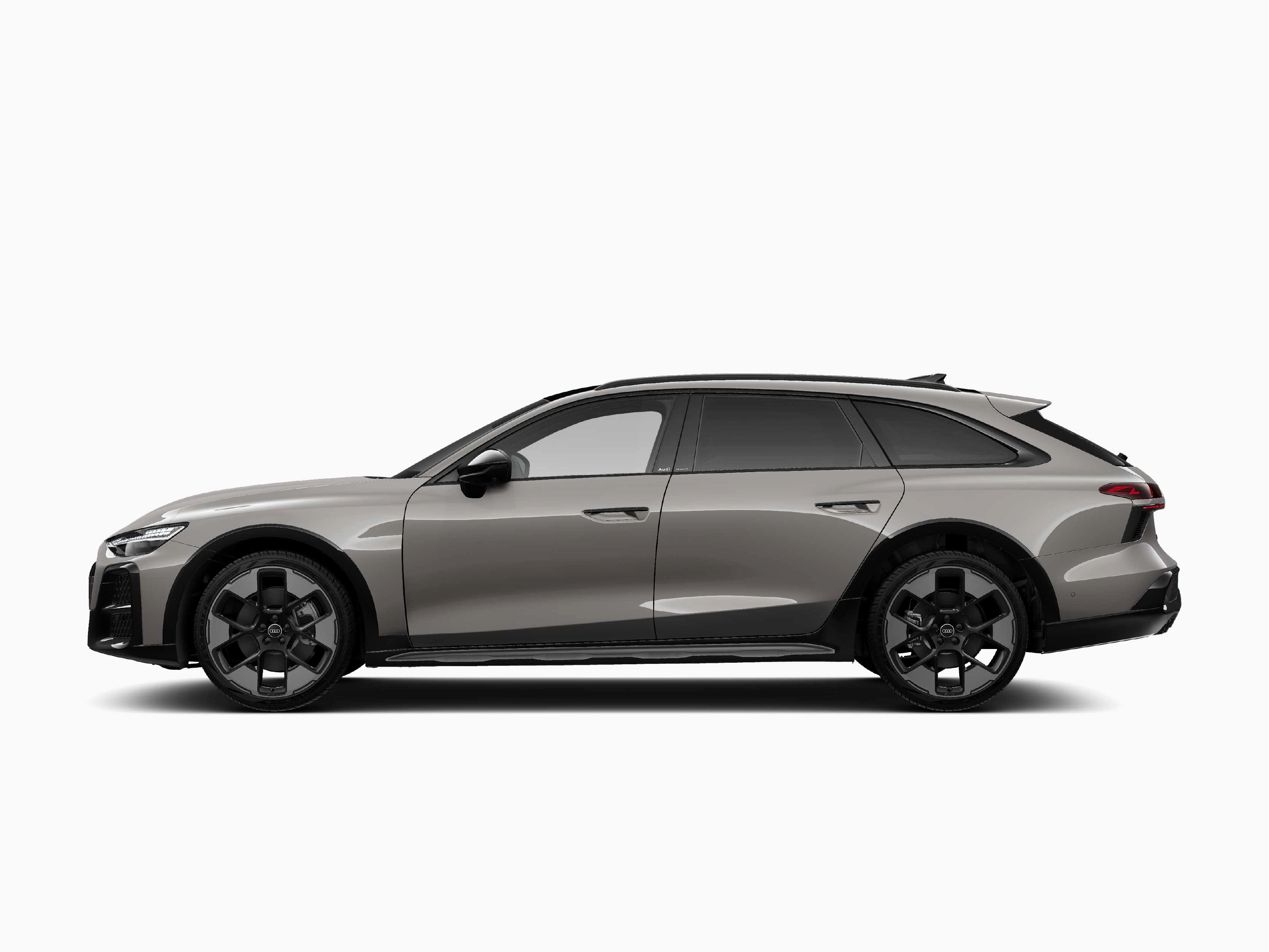 Seitenansicht eines graumetallischen Audi Kombis vor rein weißem Hintergrund. Das Fahrzeug präsentiert sich im Profil mit großen, markanten dunklen Felgen, getönten Heckscheiben und einer flachen, sportlichen Silhouette.
