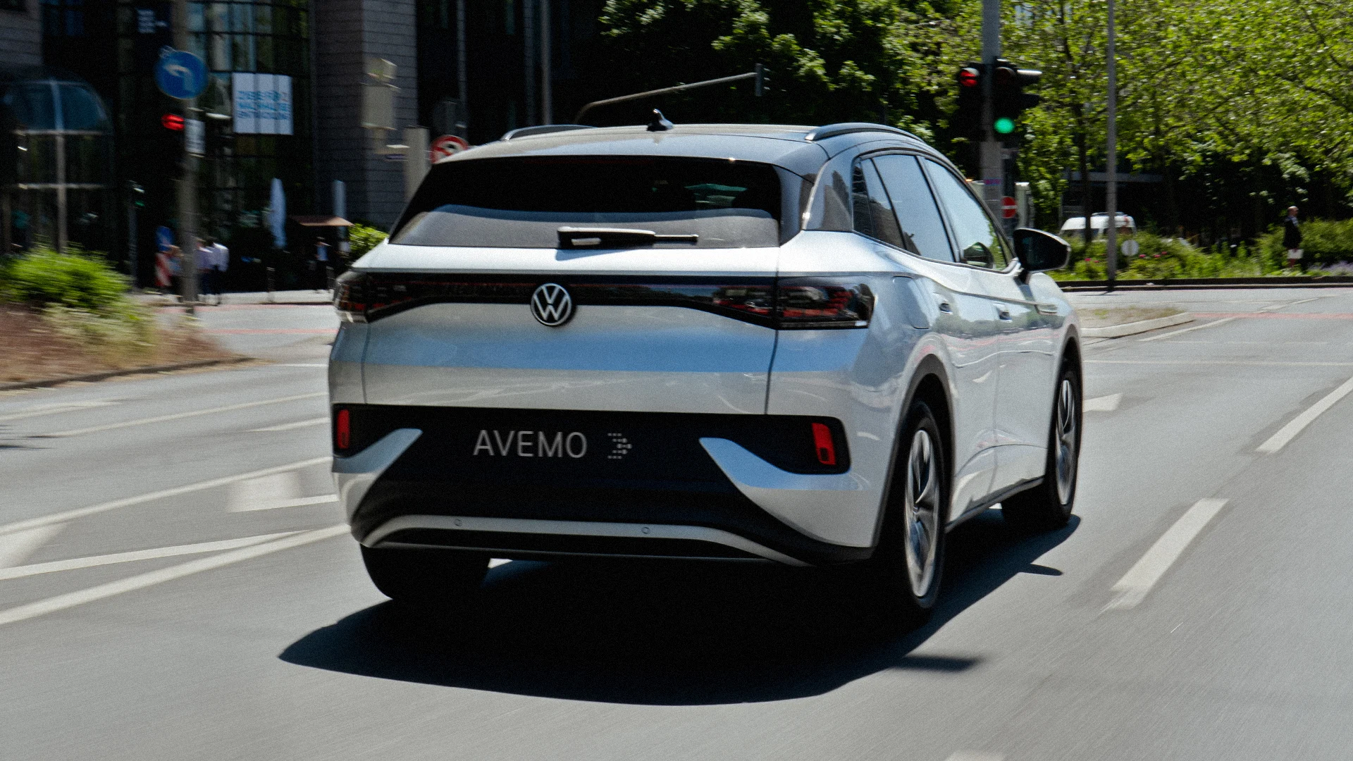 Eine Aufnahme eines Volkswagen SUVs, das in der Innenstadt auf einer Straße fährt. Das Fahrzeug ist von hinten zu sehen.