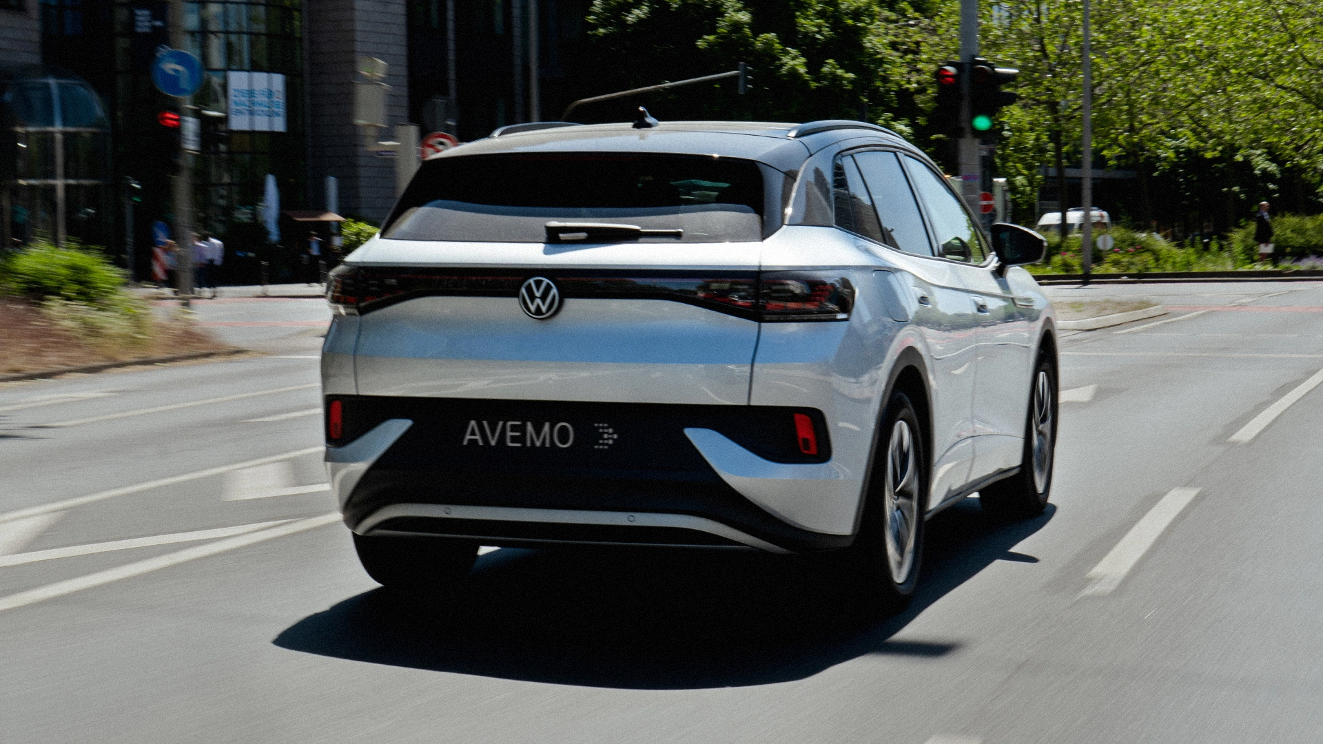 Eine Aufnahme eines Volkswagen SUVs, das in der Innenstadt auf einer Straße fährt. Das Fahrzeug ist von hinten zu sehen.